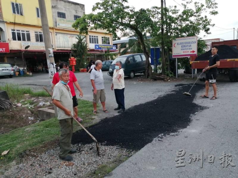 金马扬新村花园凹凸不平道路获修补工程，左为胡益彰。