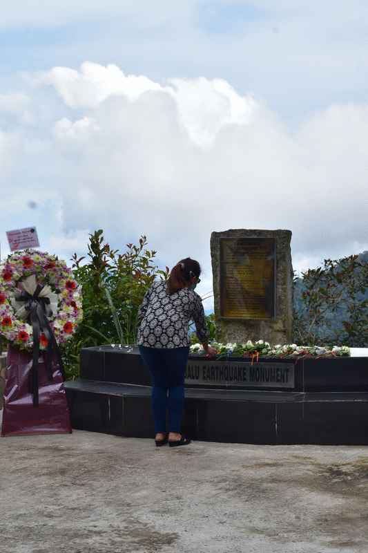 参与内部悼念活动的人员在纪念碑放上鲜花，以示对罹难者的悼念。 