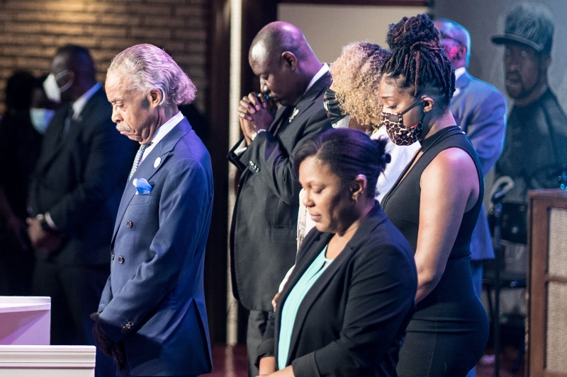 黑人民权领袖夏普顿牧师（左一）在追悼会与出席人士一同默哀。（图：法新社）