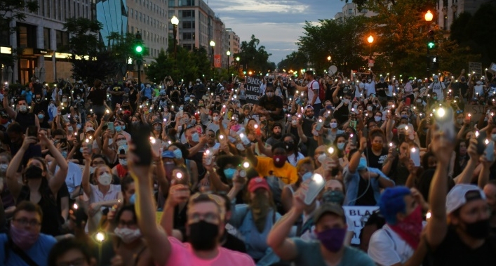 Protesters hold up their phones during a demonstration over the death of George Floyd outside the White House. AFP