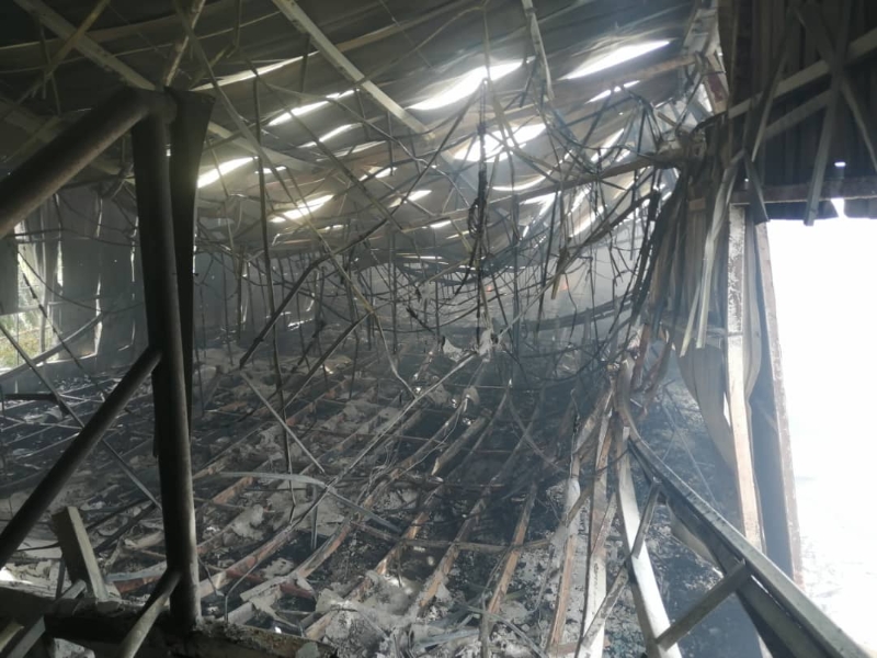 半间板厂烧毁，厂内满布倒塌的铁架。