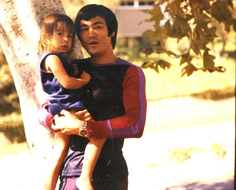 李小龙纪录片《Be Water》上线在即，外媒好奇李小龙会如何看待弗洛伊德之死，图为李小龙抱着年幼时的女儿李香凝。