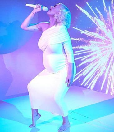 凯蒂佩莉在线上毕业典礼穿白色洋装高歌《Firework》与新歌《Daisies》，丰满身材与浑圆孕肚一览无遗，目测怀胎至少8个月。