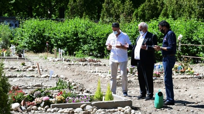 Gueddouda Boubakeur (C) praying with a mourner at his wife's grave. AFP