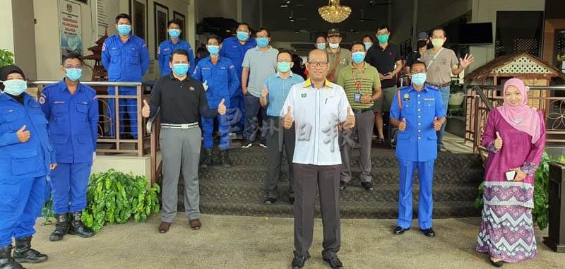 阿兹曼（前中）与依萨（右二）等人，与最后一批接受隔离者在斯里马来西亚酒店前合照，象征州内隔离中心正式全面关闭。