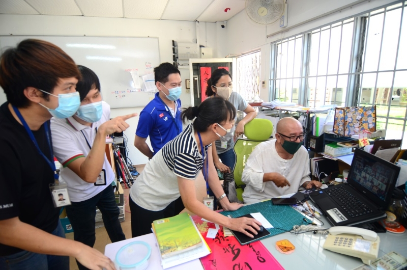 麻坡中化中学举办108生日祝福活动，筹委会成员正在讨论视频剪接等相关事谊。
