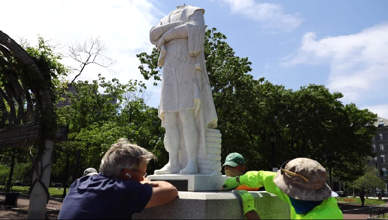 Workers from Daedalus Inc. attempt to remove a statue depicting Christopher Columbus which had its head removed at Christopher Columbus Waterfront Park in Boston. AFP