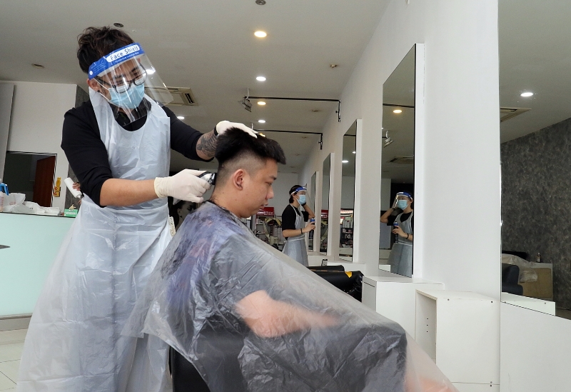 复工第一天，美发师遵照标准作业程序，“全副武装”上阵，不少男性也抢在首日剪一头清凉短发。