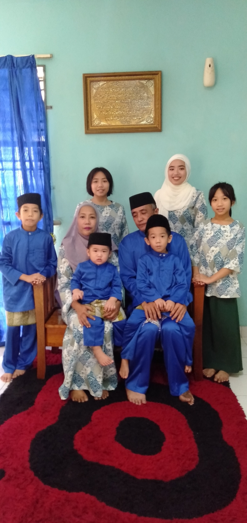 伊卡（后排左一）与家人的全家福和开斋节服装。
