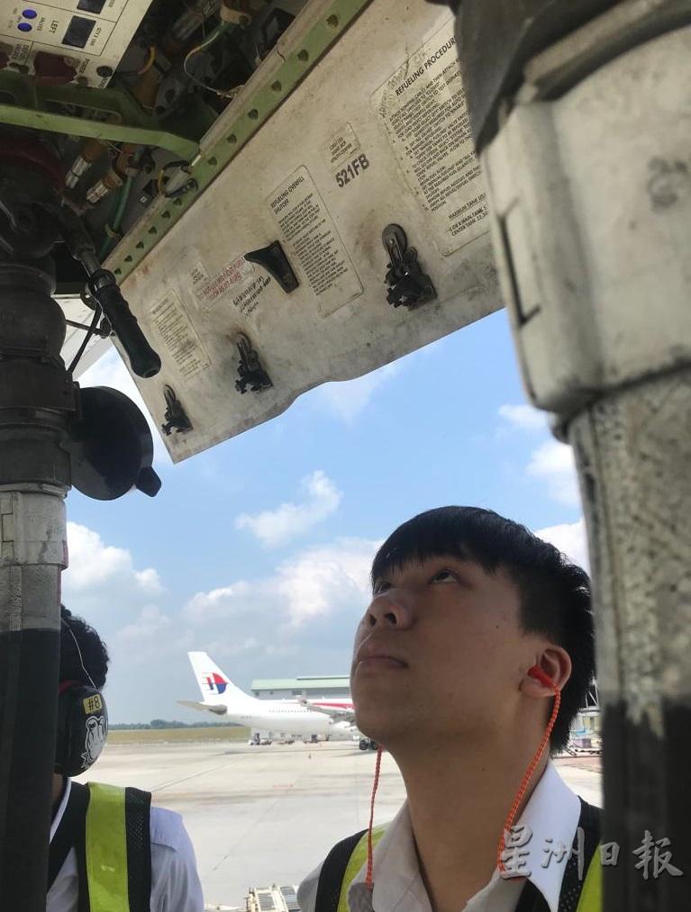 飞行检查工作责任重大，颜孙岳认真观察飞机的细微部分。

