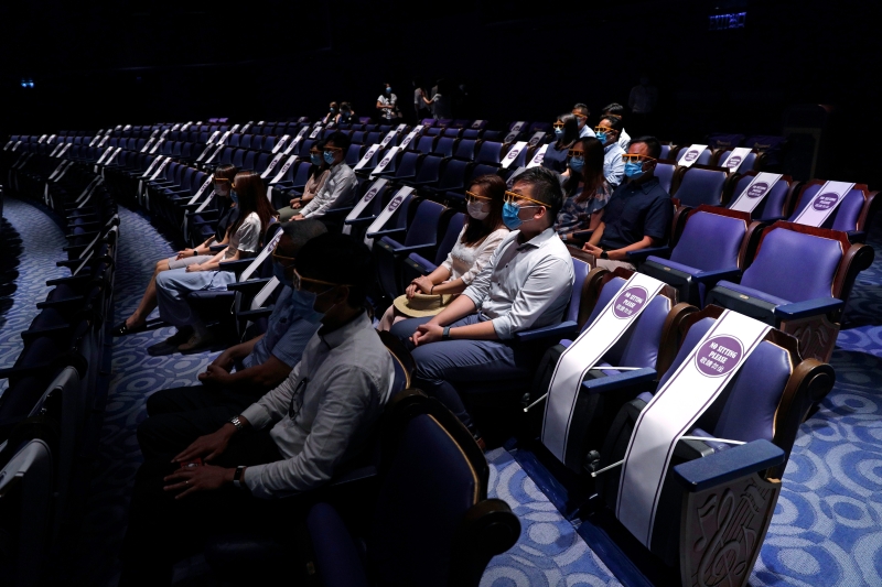 
戏院员工在媒体导览团中，为现场媒体示范在戏院观看3d电影时，如何正确做好保护措施