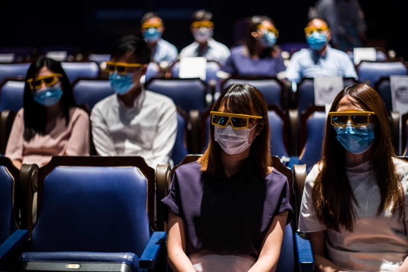 戏院员工在媒体导览团中，为现场媒体示范在戏院观看3d电影时，如何正确做好保护措施。