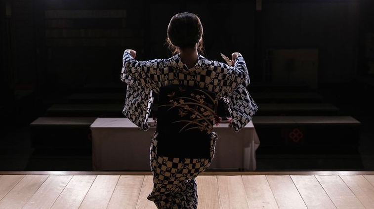 Beneath spotlights, the graceful geisha performs a traditional dance, moving like a butterfly and artfully unfolding and fluttering her fan. AFP