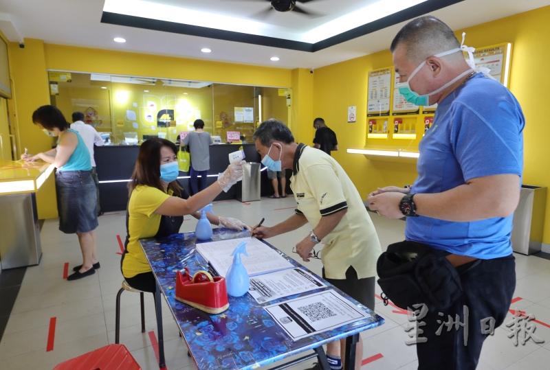 万能员工为进入投注站的民众测量体温。