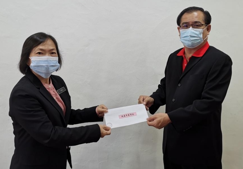 罗填水（右）代表董家教理事移交献金给王讶瑜。