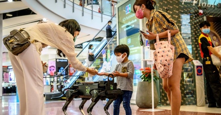 K9 distributes hand sanitizer to visitors at a shopping mall in Bangkok. AFP