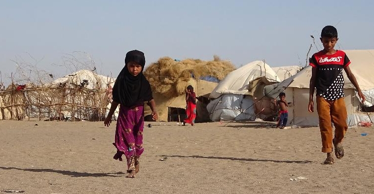 Children walk past tents at a displaced persons camp in the Khokha district of Yemen's western province of Hodeida. AFP