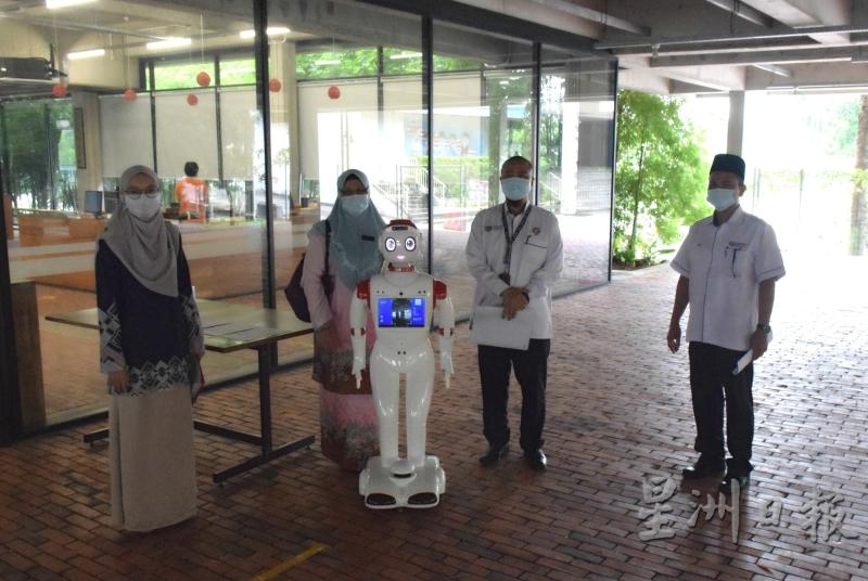 柔州教育局官员诺芝哈（左一）和莫哈末苏菲（右二）等人，都对“机器人测温机”深感兴趣。（图：星洲日报）