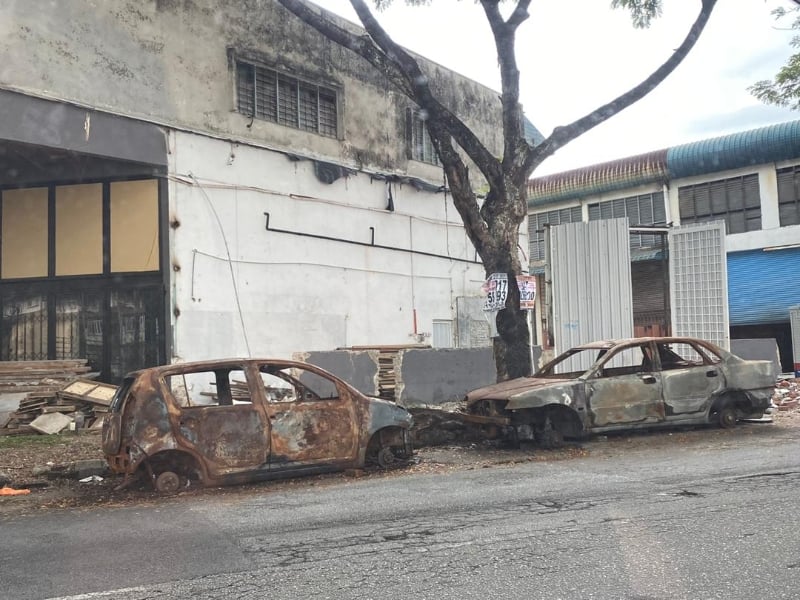 在甲洞不乏破烂得只剩外壳的废车停放在路边。