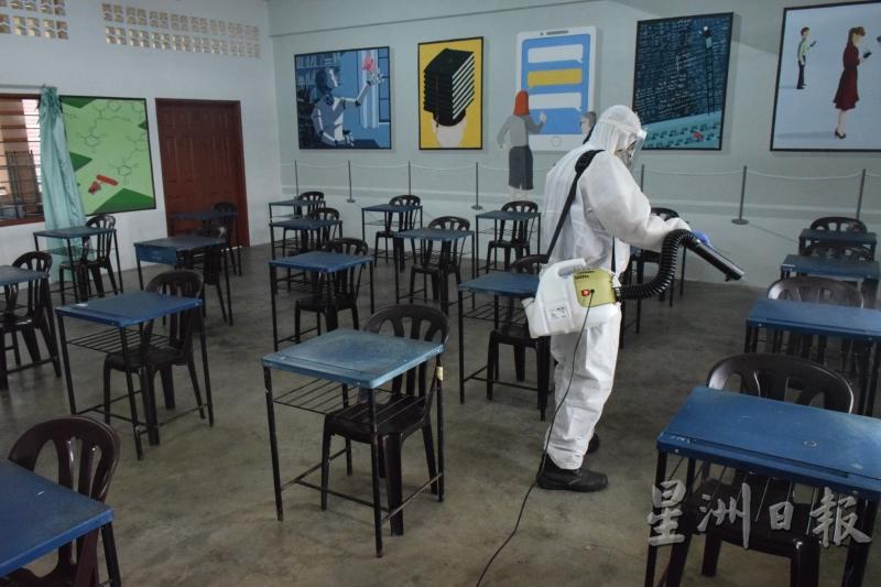 工作人员已进行课室消毒工作，而且教室桌椅都保持1公尺的距离。（图：星洲日报）