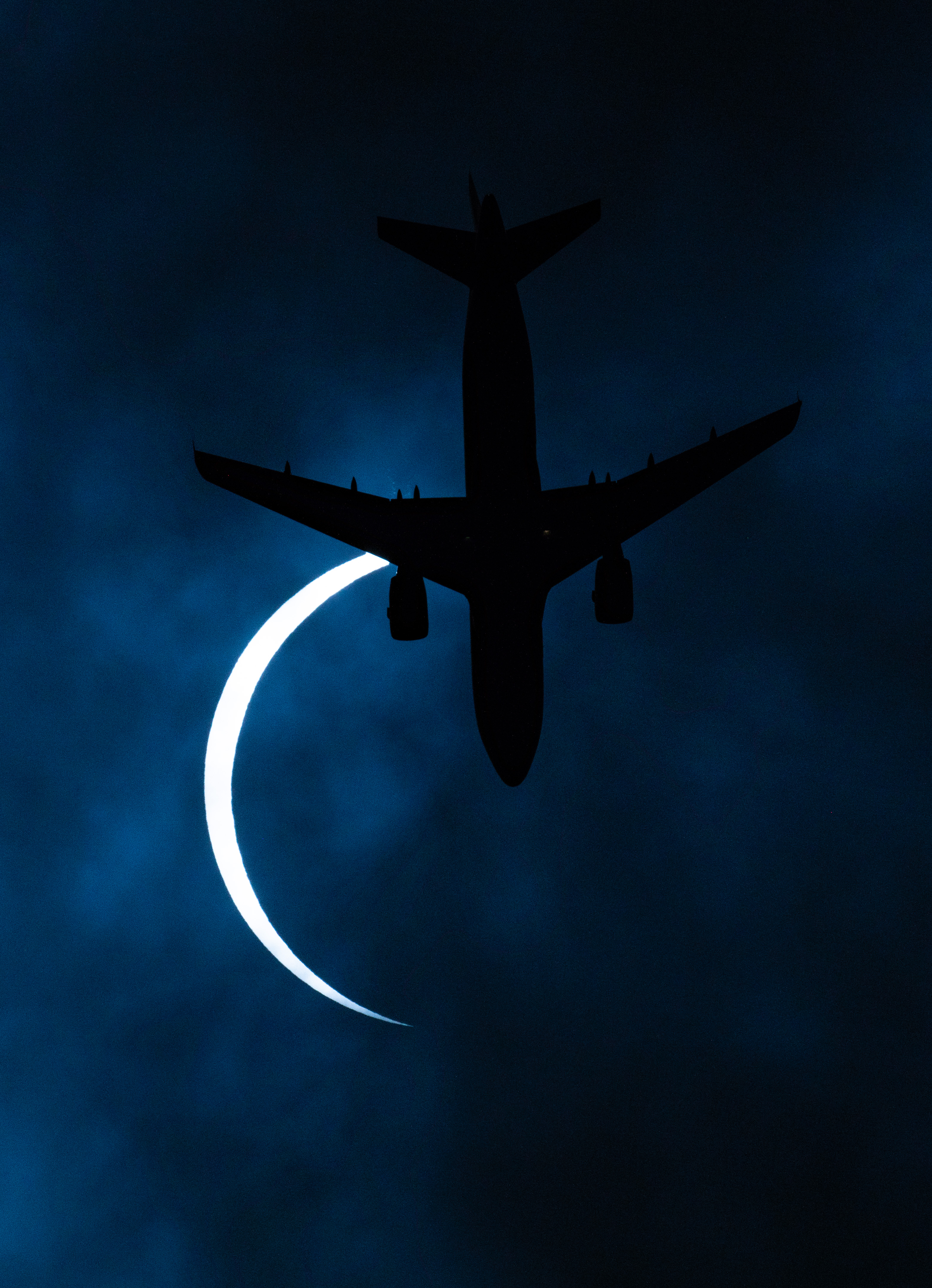 拉萨日食发生时，摄影师刚好捕捉到飞机飞过的画面。（新华社照片）