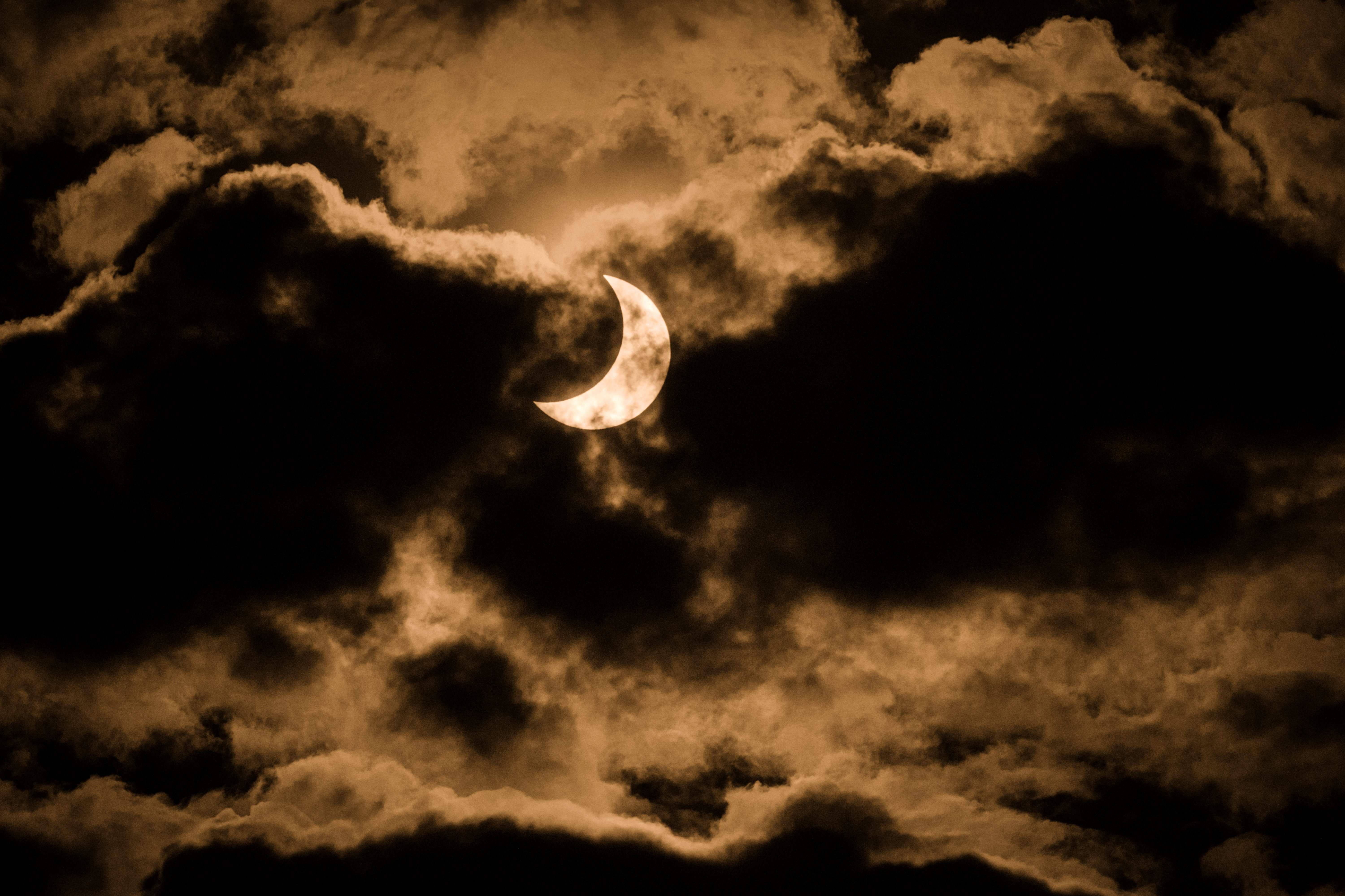 肯尼亚内罗毕天空多云，拍摄者使用红外线滤镜捕捉部分日食。 （法新社照片）