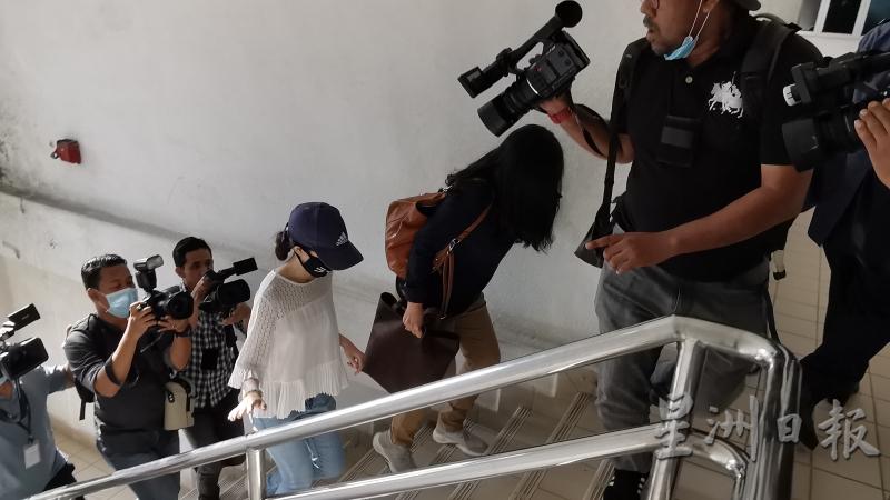 黄佩雯在母亲陪同下步上法庭聆听判决，媒体摄影记者跟拍。