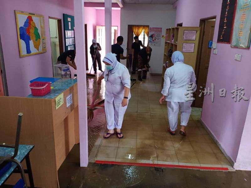 诊所护士、卫生局职员、村民连同消拯人员一同为诊所清理灾后泥泞。