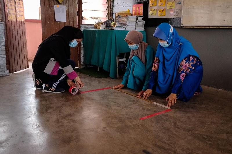吉隆坡格拉末流域中学教职人员在课室内测量距离。