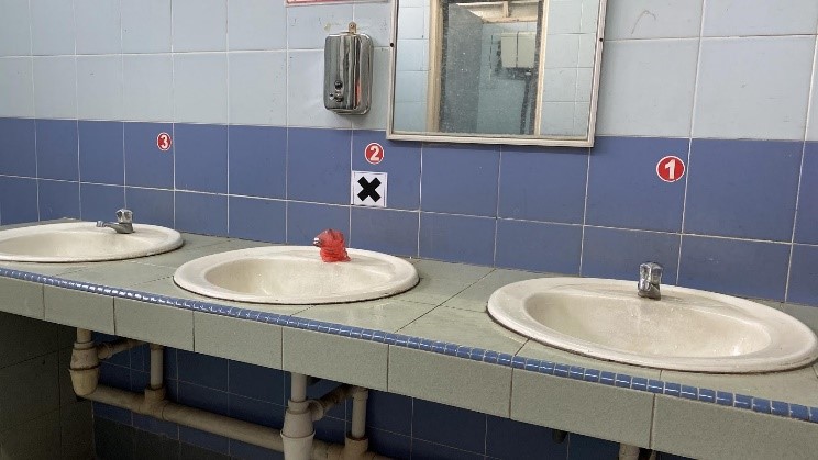 霹雳深斋中学厕所洗手台根据教育部规定，标志了社交距离符号。