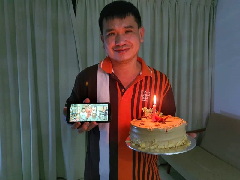 同事替黄伟文拍下一手拿著父亲节蛋糕，一手是全家福但独缺他的照片。