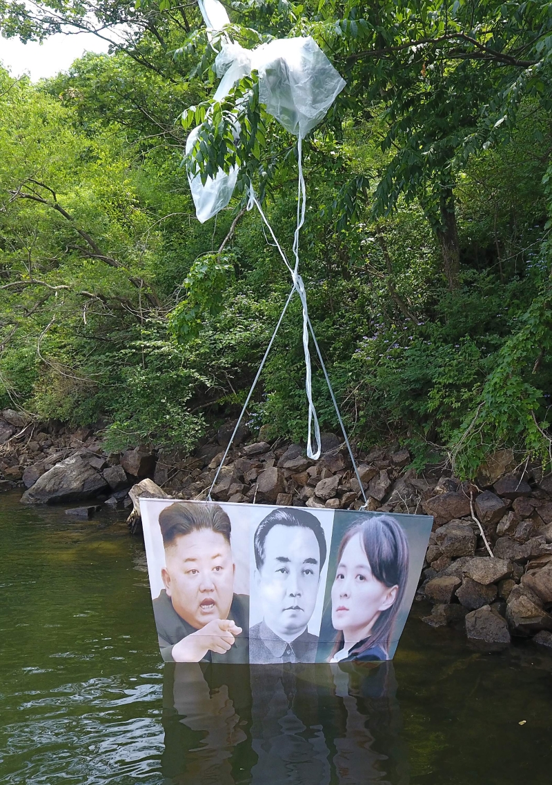 脱北者组织周二表示，他们在韩朝边境发放了装有反朝鲜的50万张传单的气球等。图为其中一个在韩国洪川郡发放、挂着朝鲜领导人金正恩（左起）、已故金日成和金正恩胞妹金与正肖像的气球落在树枝上。 （图：法新社）

