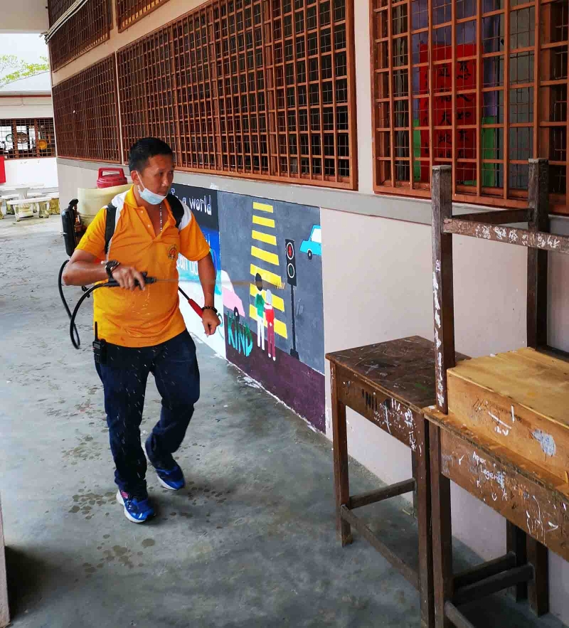 霹雳南华国民型中学校工在校内进行消毒工作。