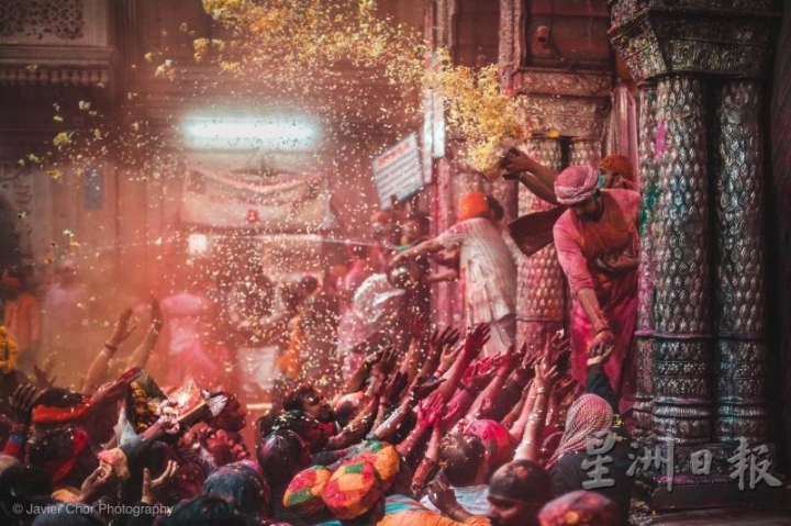 温达文（Vrindavan）Shri Bankey Bihari寺庙的祭司正向朝圣者抛洒Phoolon Ki Holi（色彩节之花）。