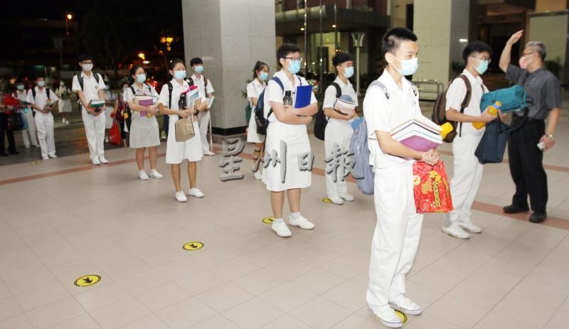 兴华中学学生在等候测量体温和使用消毒搓手液时，都保持社交距离。