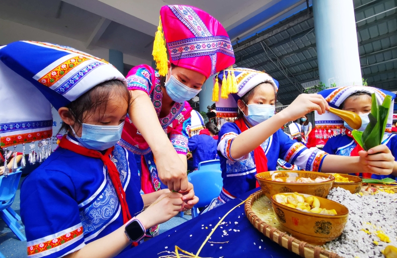 广西河池市金城江区第三小学的孩子们和家长一起包粽子。（新华社照片）