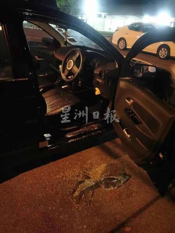 医护人员的轿车司机座位车窗玻璃被砸破，车厢内都是玻璃碎片。

