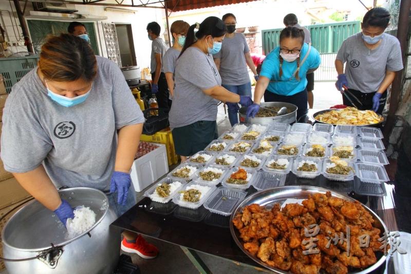 圆梦慈善义工团一大清早就会开始准备盒饭，饭盒内容非常丰盛，包括炸鸡、咸菜与鸡蛋。