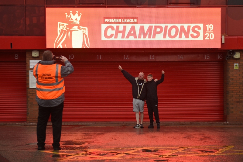 利物浦球迷在安菲尔德体育场外新竖立的“我们是冠军”标志下拍照，记下这历史性的一刻。（法新社照片）