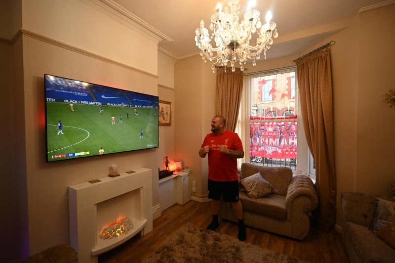 利物浦球迷在住家观赏曼市客战切尔西的比赛。曼市最终输球，利物浦提前夺冠。（法新社照片）