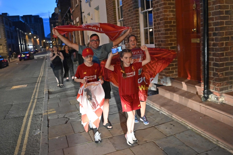 在利物浦抵定夺下英超冠军后，红军球迷一家外出游街庆祝。（法新社照片）
