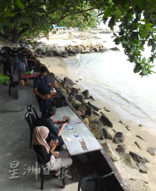 游客享受海滨小贩美食。
