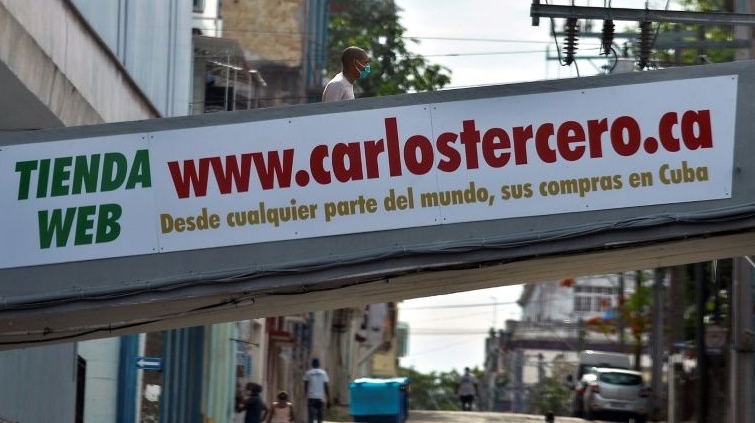 A man walks across a bridge with an advertising of an online store reading 