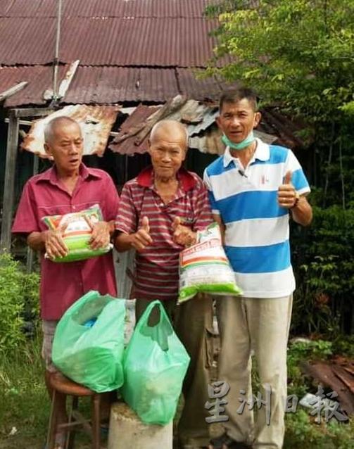曾贵兴（右起）曾在今年4月，派发干粮和援助品给李玡和另一孤老。