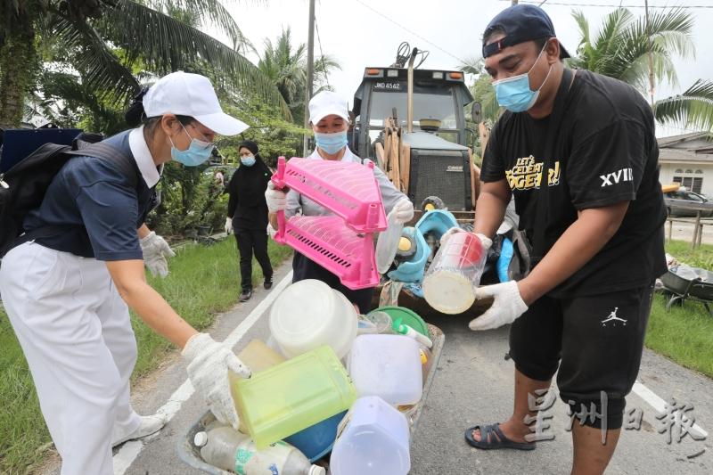 慈济志工与灾黎合作清理灾区时，也不忘把垃圾分类。