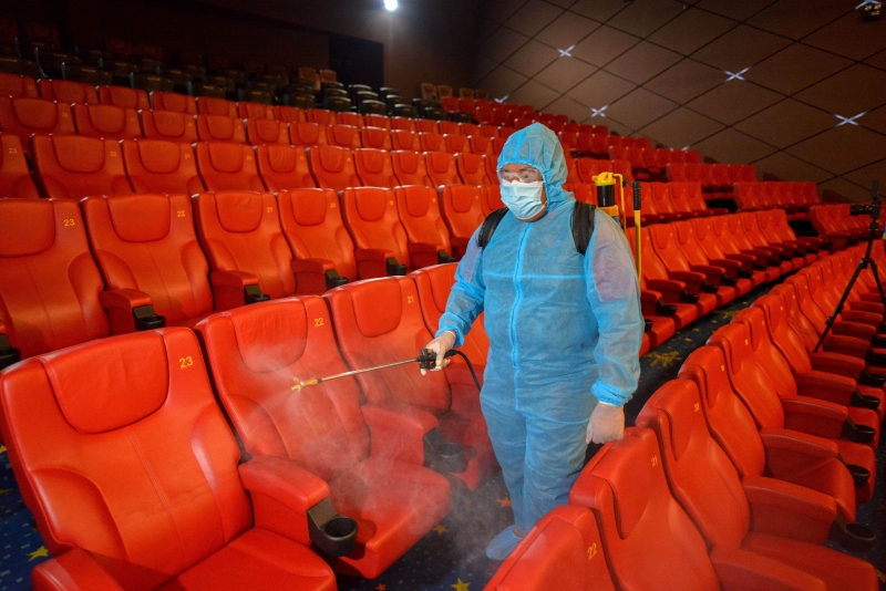 电影院员工为座椅喷洒消毒水，为即将重开的影厅展开大清洗。（新华社图）