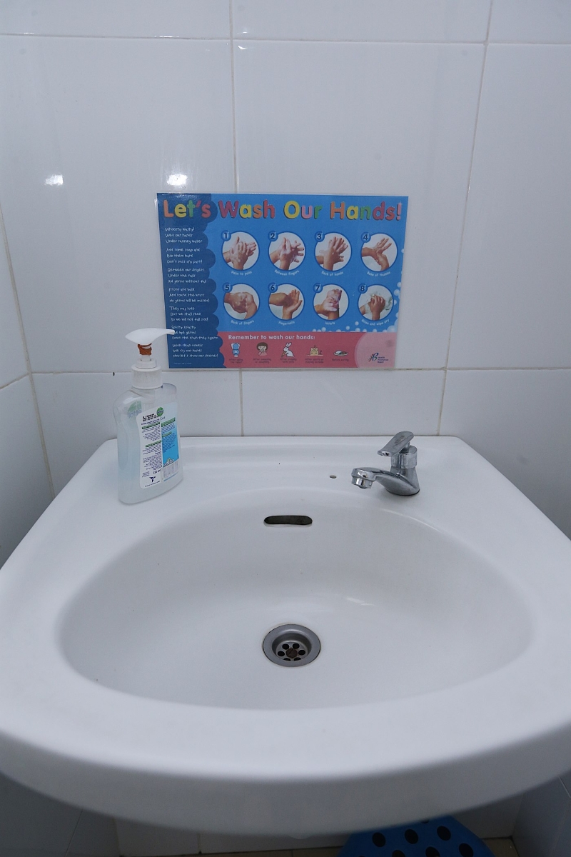 学前教育中心业者在洗手盆前贴上正确的洗手步骤。
