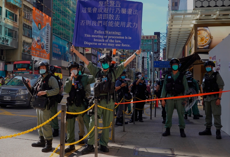 香港警察举起蓝旗警告参与游行的人士尽快散去。（美联社照片）