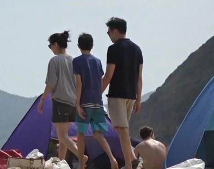 张智霖、袁咏仪一家三口T恤短裤和人字拖走沙滩。
