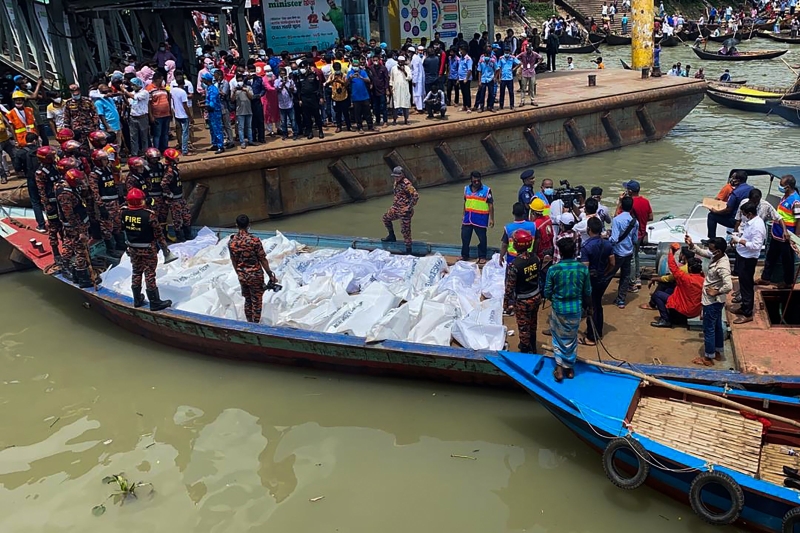 救援人员将从失事渡轮捞起的数十具遗体保送上岸，许多民众在岸边围观。（法新社照片）